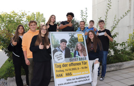 Eine Gruppe Schülerinnen und Schüler mit dem Plakat "Tag der offenen Tür"